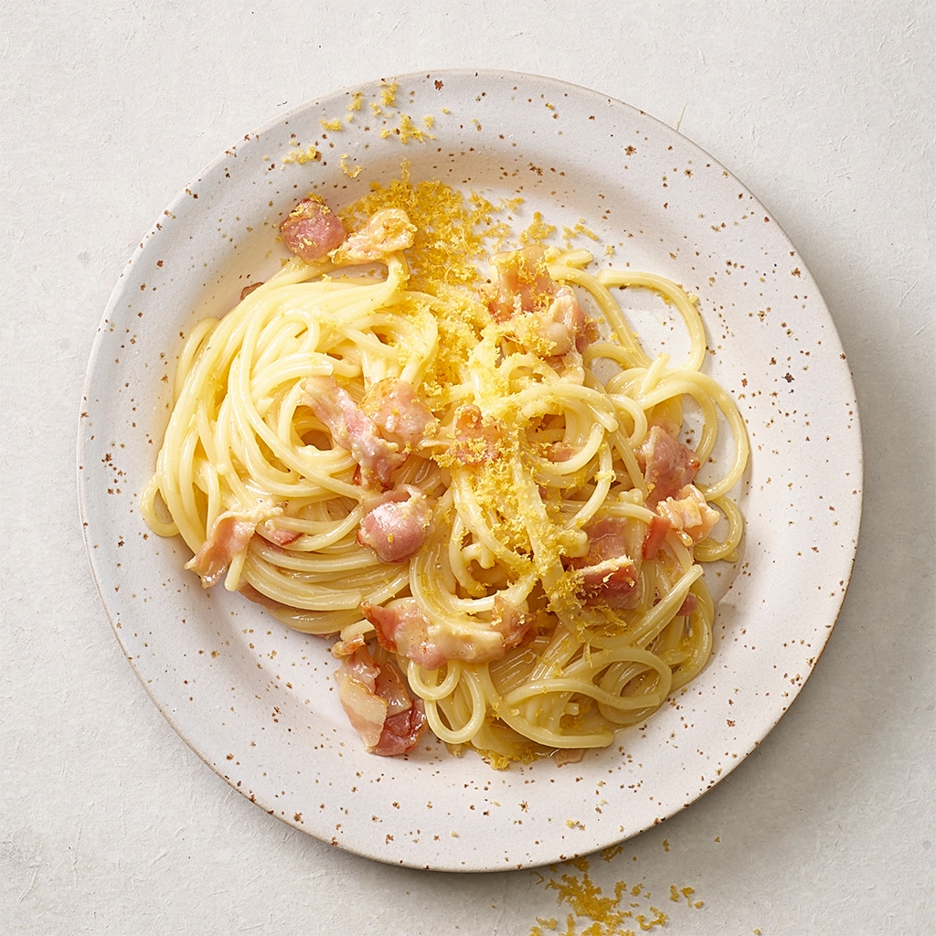 Spaghetti Carbonara mit geriebenem, gebeiztem Eigelb