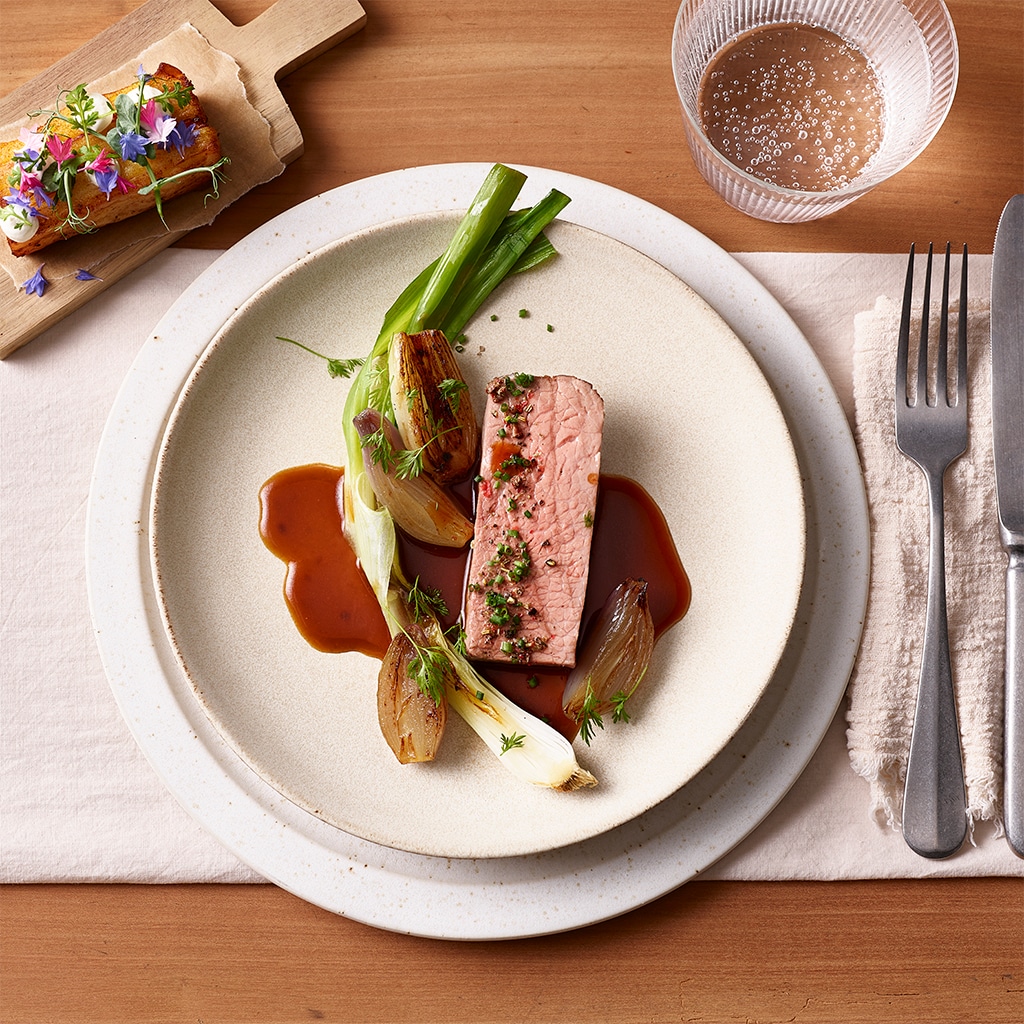 Rosa gebratene Rinderhuft mit Jungzwiebel und Rotweinsauce