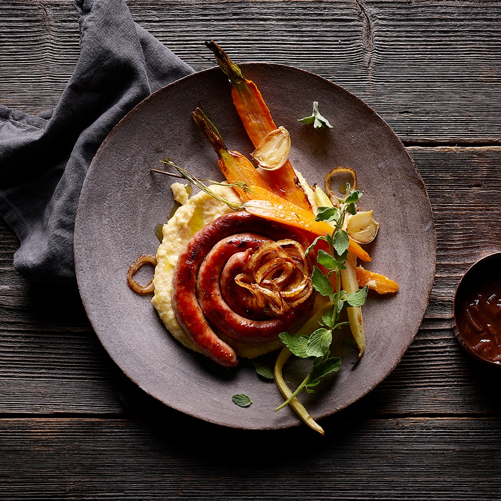Gegrillte Schweinsbratwurst mit Polenta und Ofenkarotten
