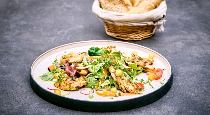 Bunte Blattsalate mit gegrillten Hühnerbruststreifen, Croutons und klarem Dressing